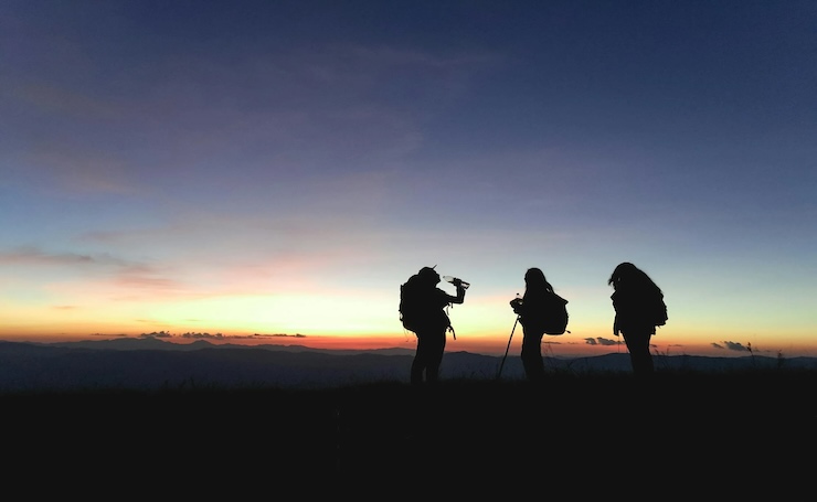 amici che fanno un trekking al tramonto