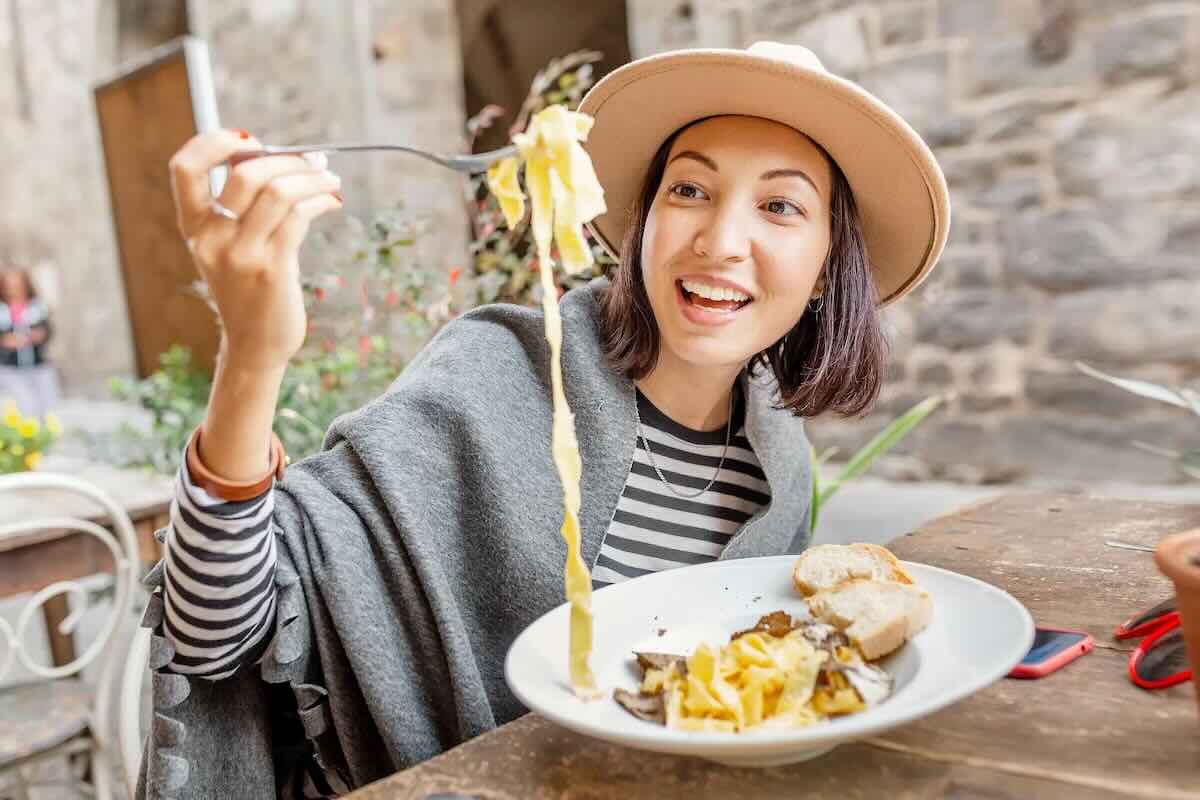 ragazza che mangia tagliatelle al tartufo