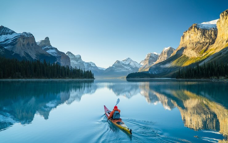 ragazzo con il kayak tra le montagne